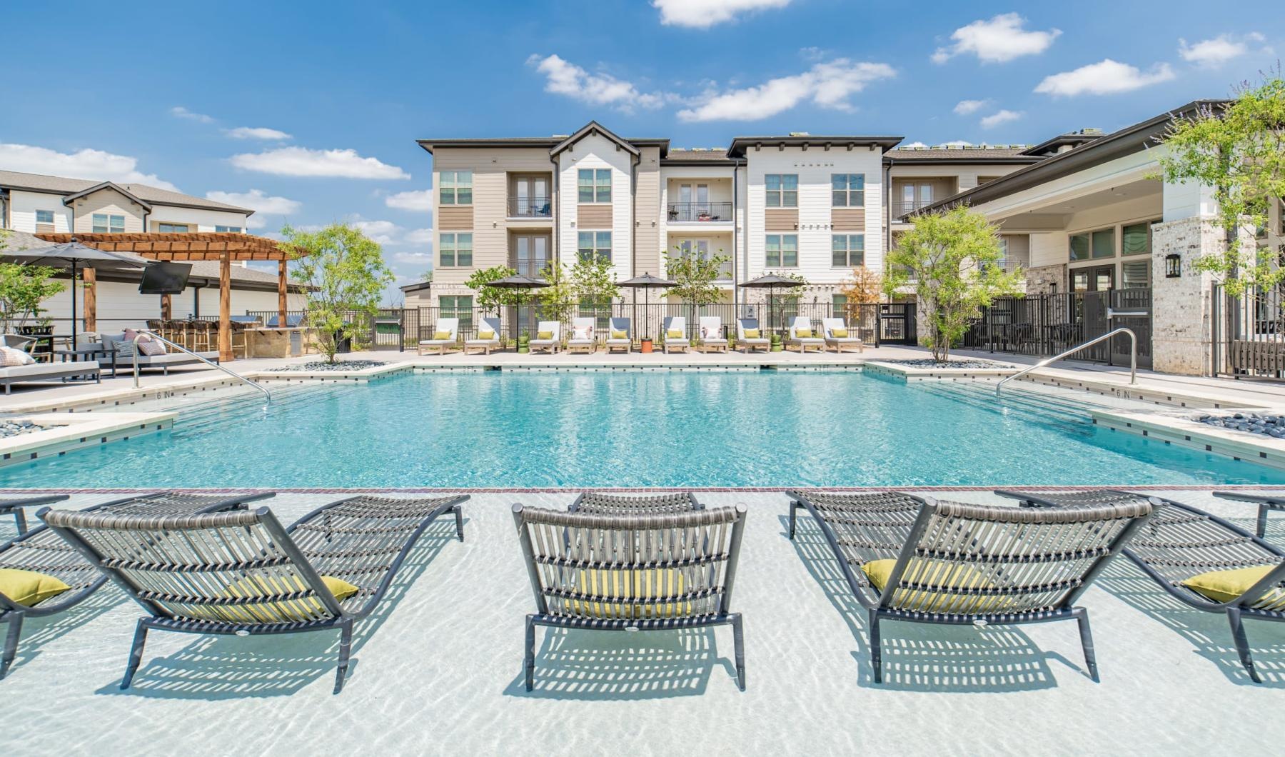 a swimming pool with chairs around it