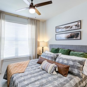 a bedroom with a fan and a bed